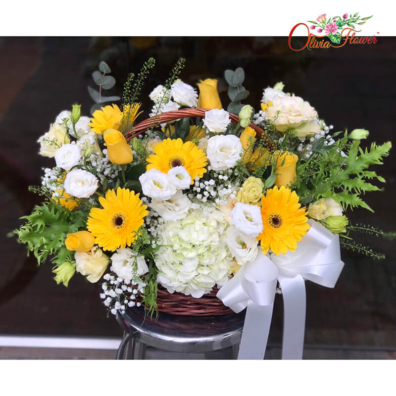 กระเช้าดอกไม้สด ประกอบด้วย ดอกกุหลาบเหลือง 15 ดอก ดอกเยอบีร่าเหลือง 6 ดอก ดอกไฮเดรนเยียขาว 2 ดอก ดอกไลเซนทรัสสีพีช ดอกไลเซนทรัสขาว ยิปซี