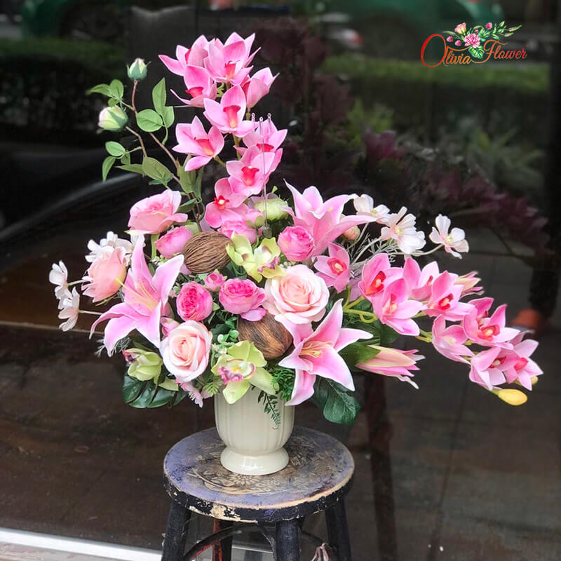 แจกันดอกไม้ประดิษฐ์ โทนสีชมพู ดอกไม้ที่ใช้ตามแบบ หรืออาจเปลี่ยนดอกไม้บางอย่าง แต่ทางร้านจะคัดสรรดอกไม้เกรดที่ดีที่สุด ใกล้เคียงแบบที่สุดโดยไม่ทำให้เสียรูปทรง หรือผิดสี