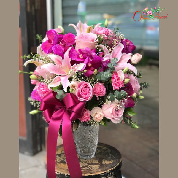 แจกันดอกไม้สด ประกอบด้วย ลิลลี่สีชมพู 4 ดอก แวนด้า กุหลาบสีชมพู คาร์เนชั่นสีชมพู ไลเซนทรัสสีชมพู ยิบซี และใบยูคา