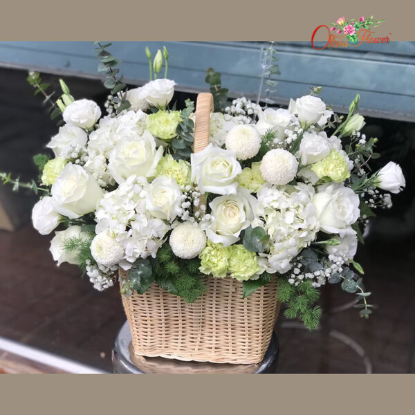 กระเช้าดอกไม้สด ประกอบด้วย กุหลาบสีขาว ไฮเดรนเยียสีขาว คาร์เนชั่นสีเขียว มัมปิงปอง ไลเซนทรัสสีขาว ยิปซี ใบยูคา และใบปริก