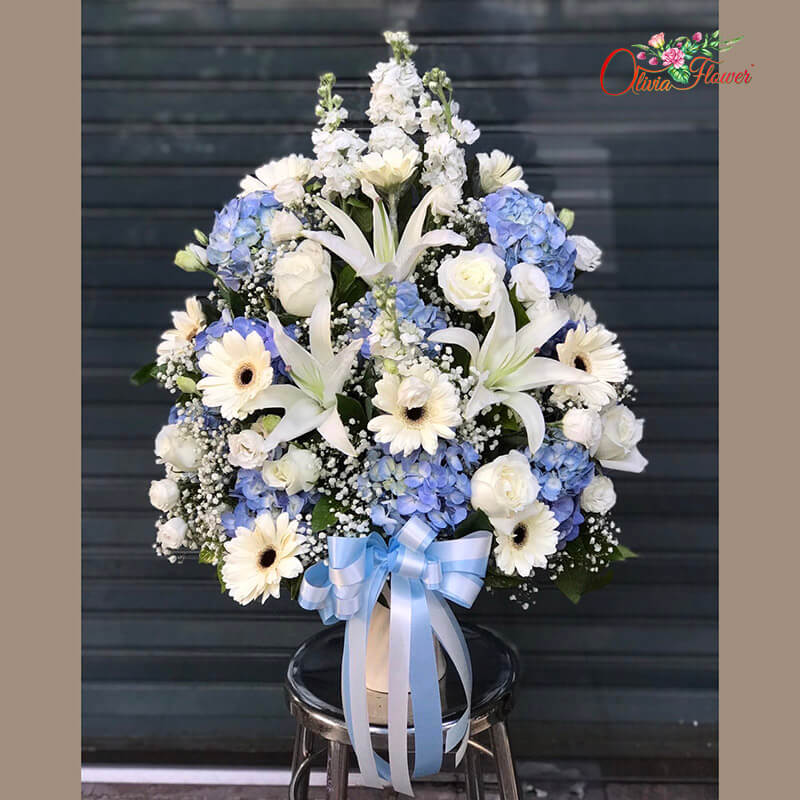 แจกันดอกไม้สด ประกอบด้วย กุหลาบสีขาว ลิลลี่สีขาว เยอบีร่าสีขาว สต็อคสีขาว ไลเซนทรัสสีขาว ยิบซี และใบนาคราช