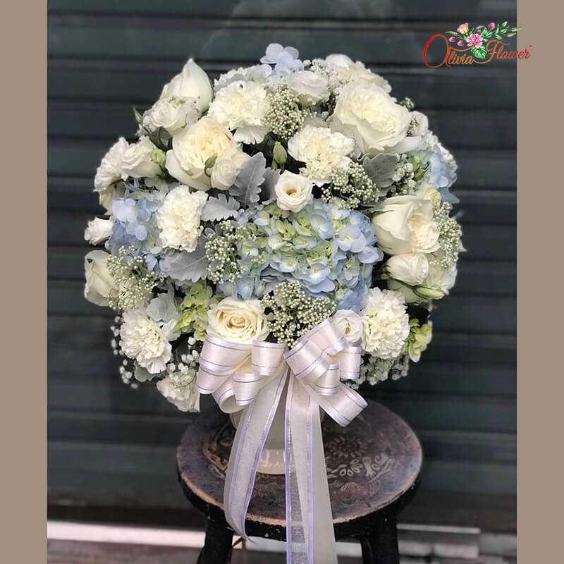 แจกันดอกไม้สด ประกอบด้วย กุหลาบสีขาว ไฮเดรนเยียสีฟ้า คาร์เนชั่นสีขาว ยิบซี และใบหิมะ