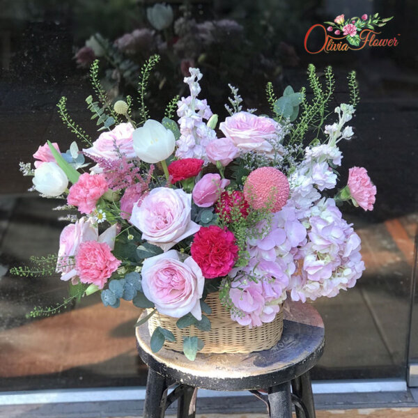 กระเช้าดอกไม้สด ประกอบด้วย กุหลาบสีชมพู ไฮเดรนเยียสีชมพู ทิวลิปสีขาว คาร์เนชั่นสีชมพู สต็อคสีขาว แคสเปีย และใบยูคา