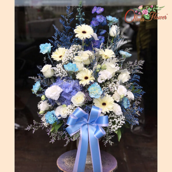 แจกันดอกไม้สด โทนสีฟ้า ประกอบด้วย ดอกกุหลาบ สีขาว 6 ดอก ดอกเยอบีร่า สีขาว 5 ดอก ดอกคาร์เนชั่นพ่นสีฟ้า 10 ดอก ไลเซนทรัสสีขาว ยิปซี แคสเปีย