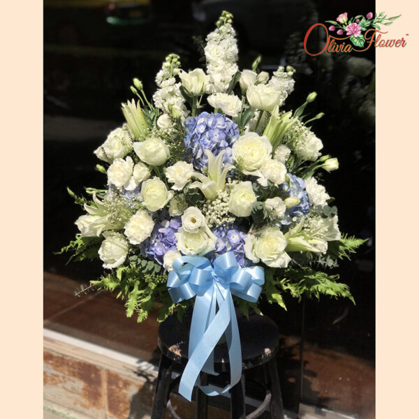 แจกันดอกไม้สด ประกอบด้วย ดอกสต็อคสีขาว 3 ดอก ดอกไฮเดรนเยียสีฟ้า 4 ดอก ดอกกุหลาบสีสีขาว 15 ดอก ดอกลิลลี่ขาว 5 ดอก ดอกไลเซนทัสขาว ยิปซี แคชเปีย ใบยูคา